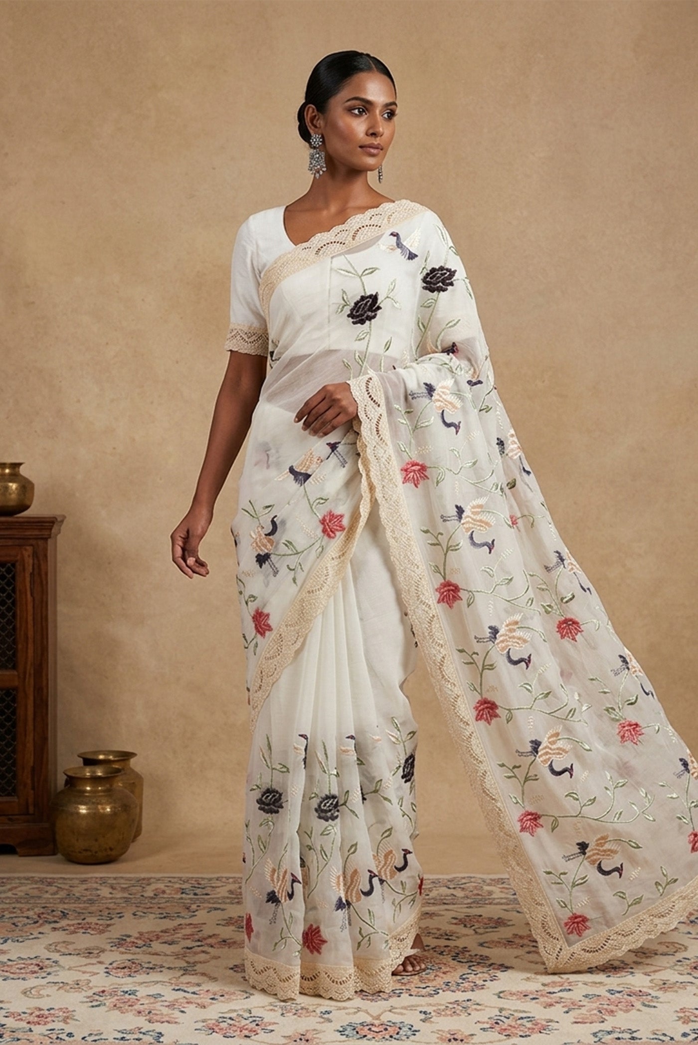 Model wearing a Off White Organza Silk Saree with Embroidery on the body and Embroidery Border.