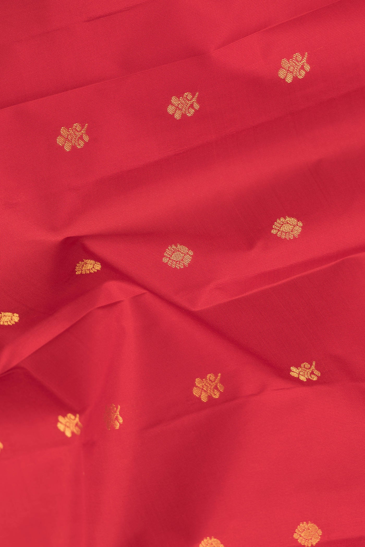 Close up of Maroon Dual Tone Kanchipuram Silk Saree with Zari Butta on the body and Zari Border.  displaying folds