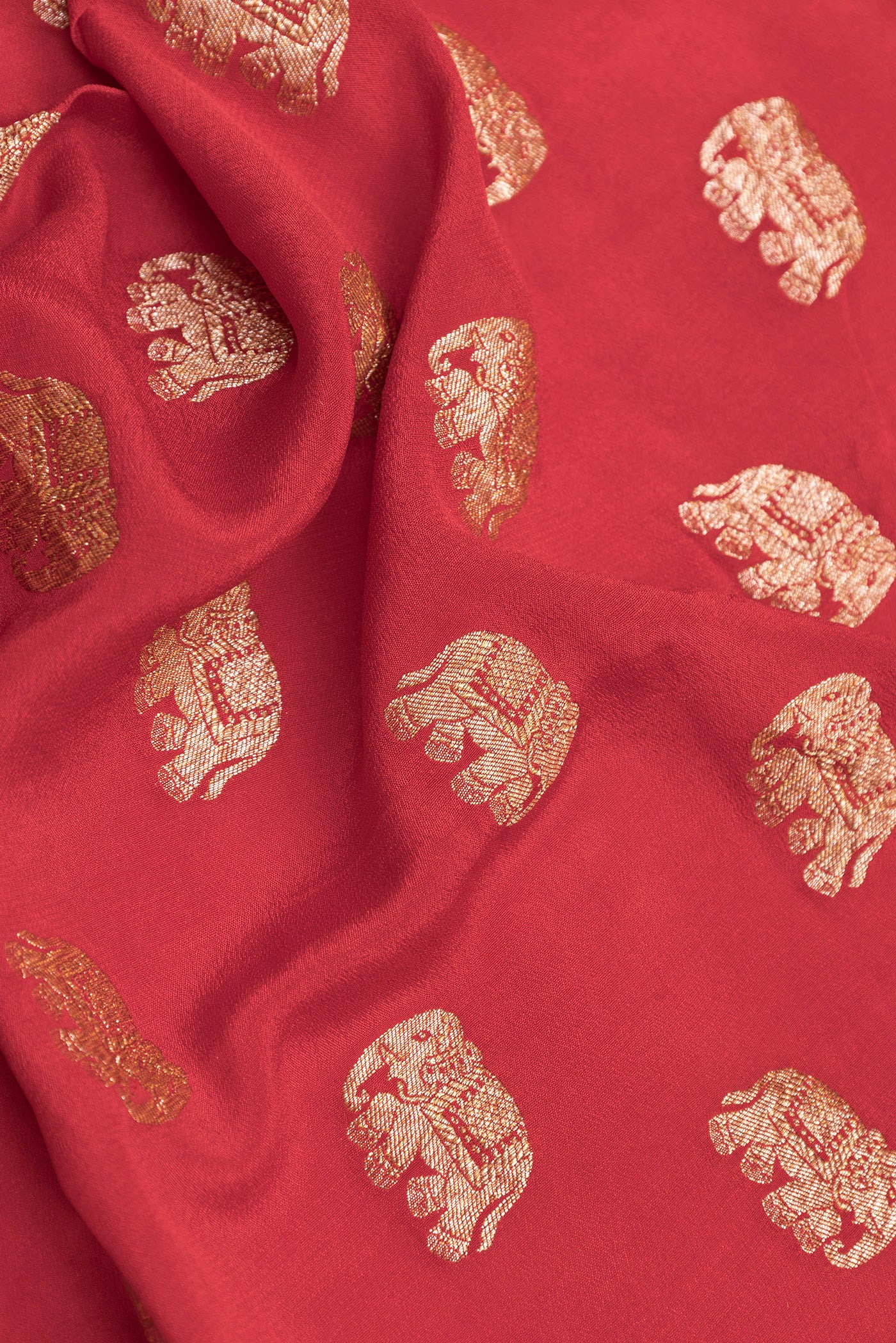 Close up of Deep Red Dual Tone Banarasi Georgette Saree with Zari Butta on the body and Zari Border.  displaying folds