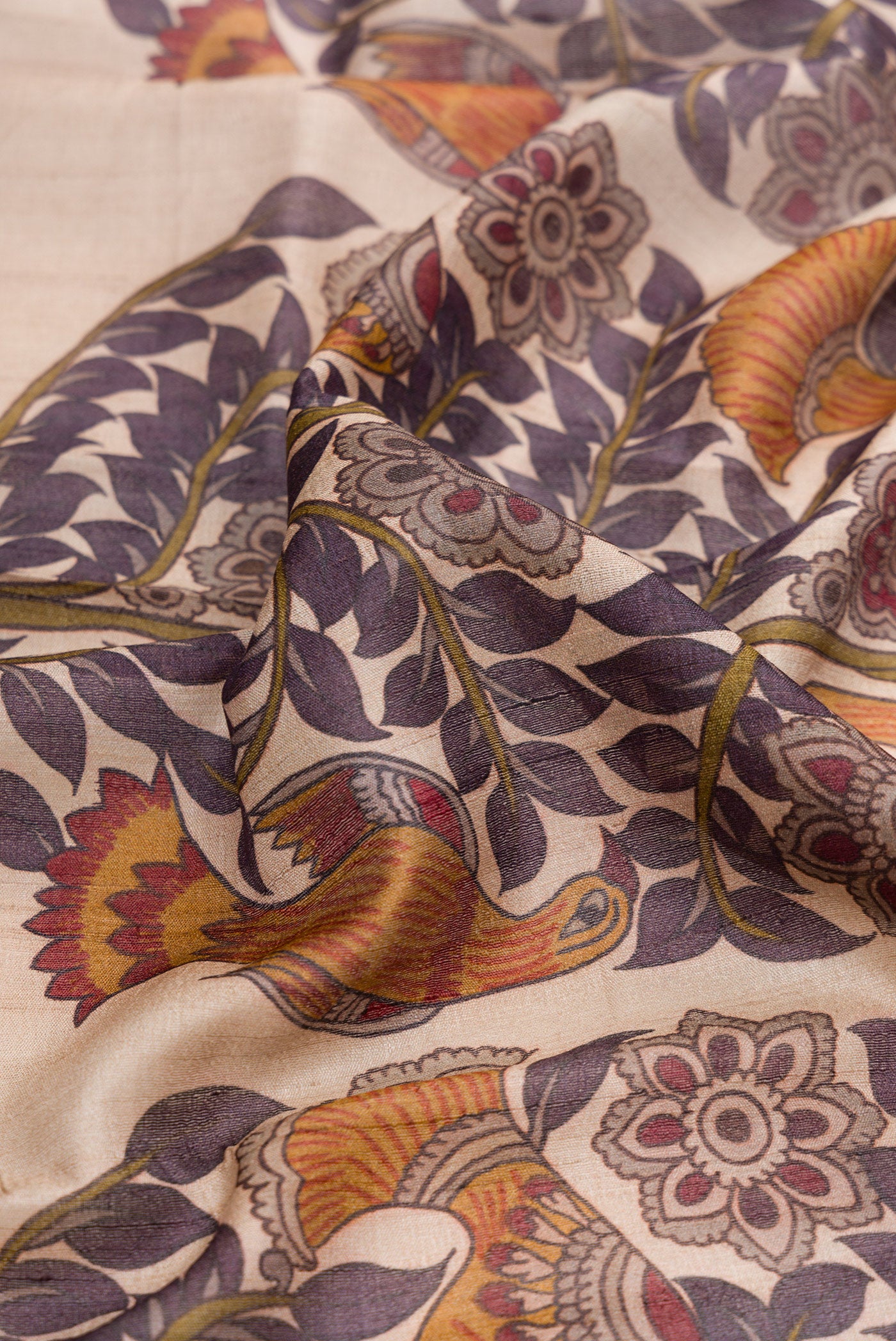 Close up of Purple Dual Tone Tussar Silk Saree with Printed design on the body and Zari Border.  displaying folds