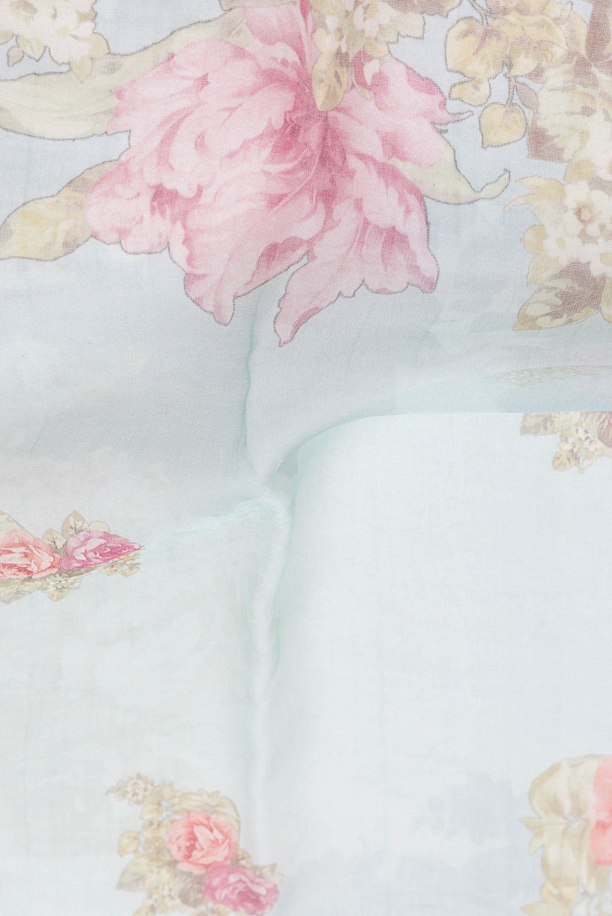 Close up of Sky Blue Organza Silk Saree with Floral Print on the body and Thin Zari Line.  displaying folds
