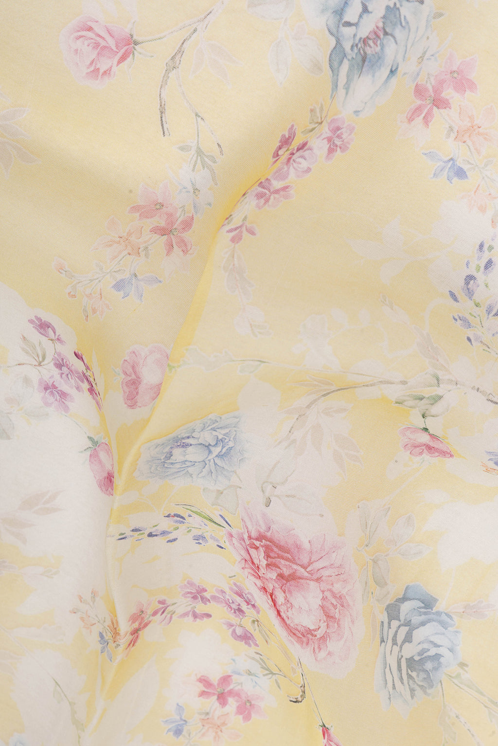 Close up of Lemon Yellow Organza Silk Saree with Printed design on the body and Without Border.  displaying folds