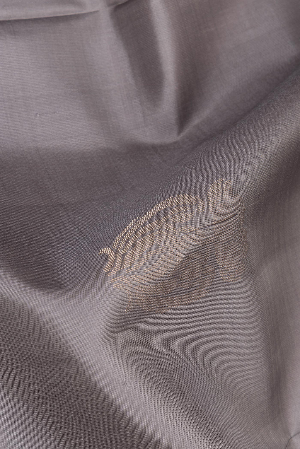 Close up of Pure Silk Grey Dual Tone Soft Saree with Zari Butta on the body and Zari Border.  displaying folds