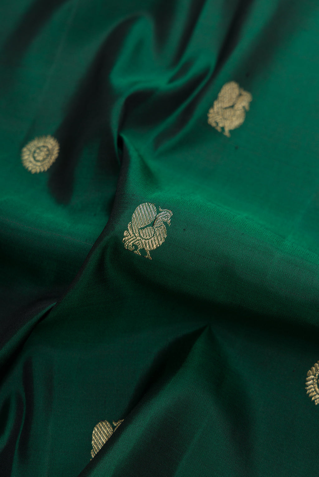 Close up of Bottle Green Dual Tone Kanjivaram Silk Saree with Zari Butta on the body and Checks Border.  displaying folds