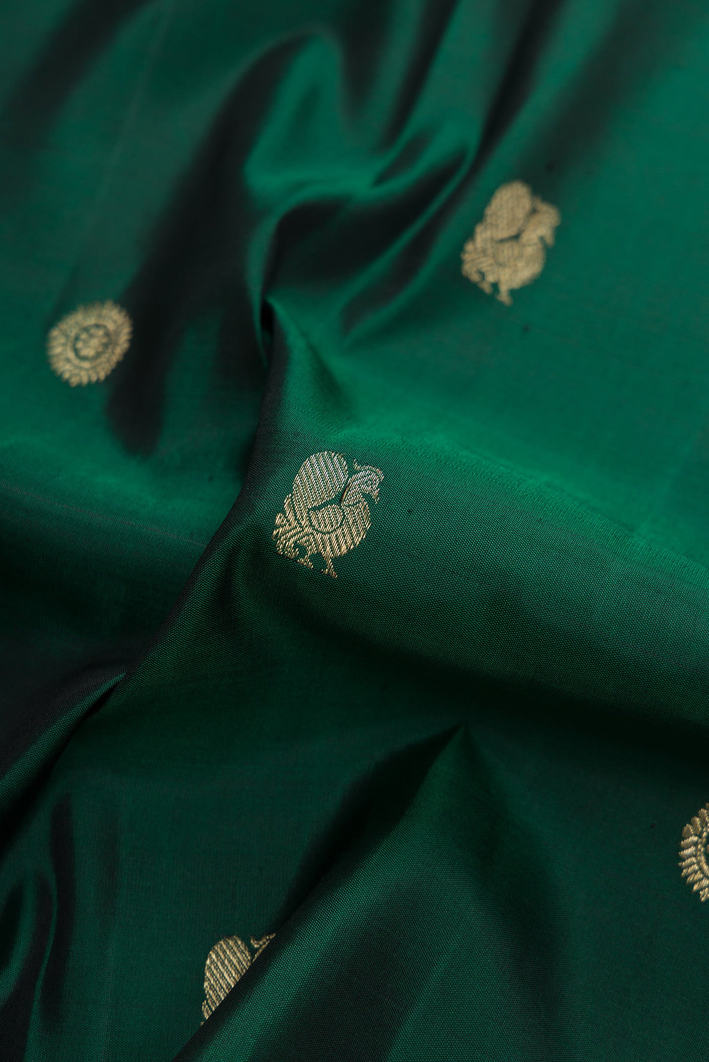 Close up of Bottle Green Dual Tone Kanjivaram Silk Saree with Zari Butta on the body and Checks Border.  displaying folds