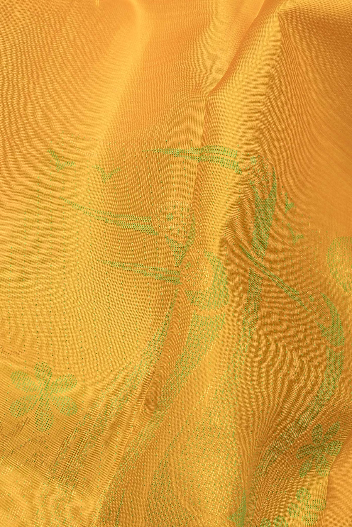 Close up of Pure Silk Mustard Dual Tone Kanjivaram Saree with Zari And Thread Butta on the body and Without Border.  displaying folds