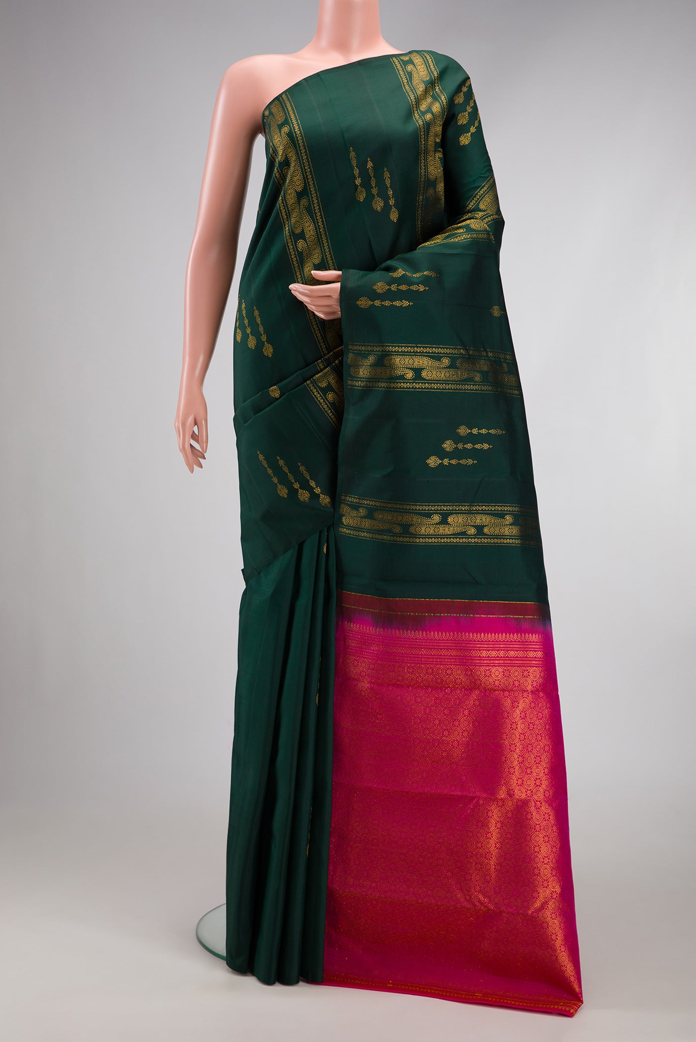 Bottle Green Kanchipuram Silk Saree with Zari Butta on the body and Without Border.  displayed on a mannequin