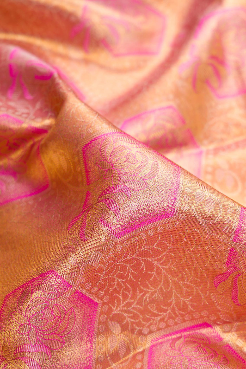 Close up of Peach Dual Tone Kanchipuram Tissue Silk Saree with Zari Brocade on the body and Fancy Border.  displaying folds
