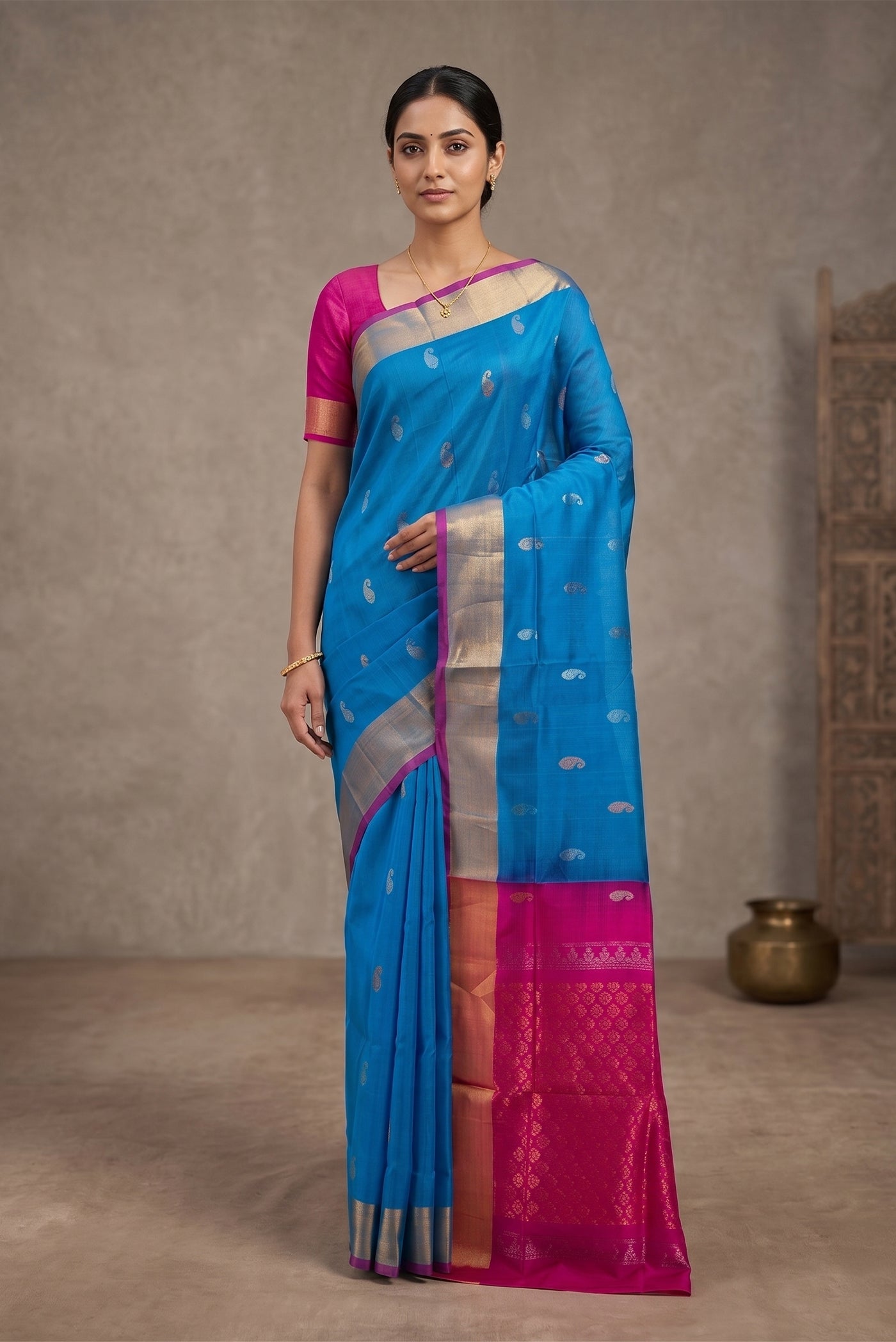 Model wearing a Peacock Blue Uppada Silk Saree with Zari Butta on the body and Zari Border.