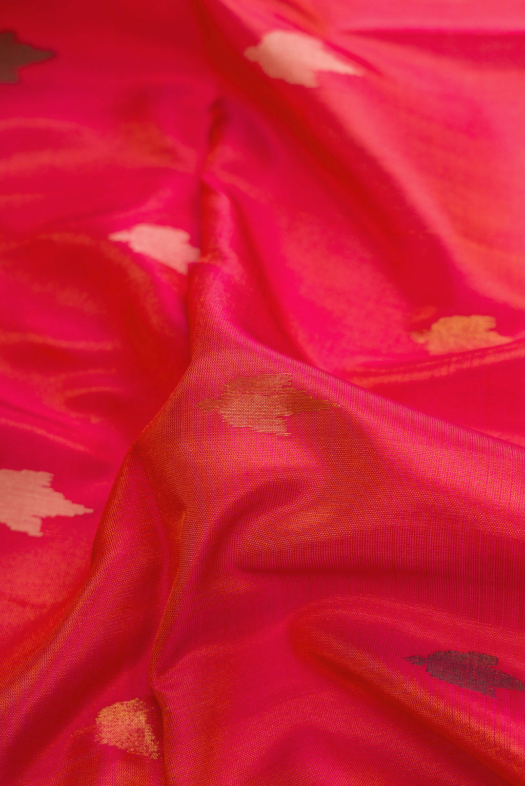 Close up of Coral Dual Tone Uppada Silk Saree with Zari And Thread Butta on the body and Zari Border.  displaying folds