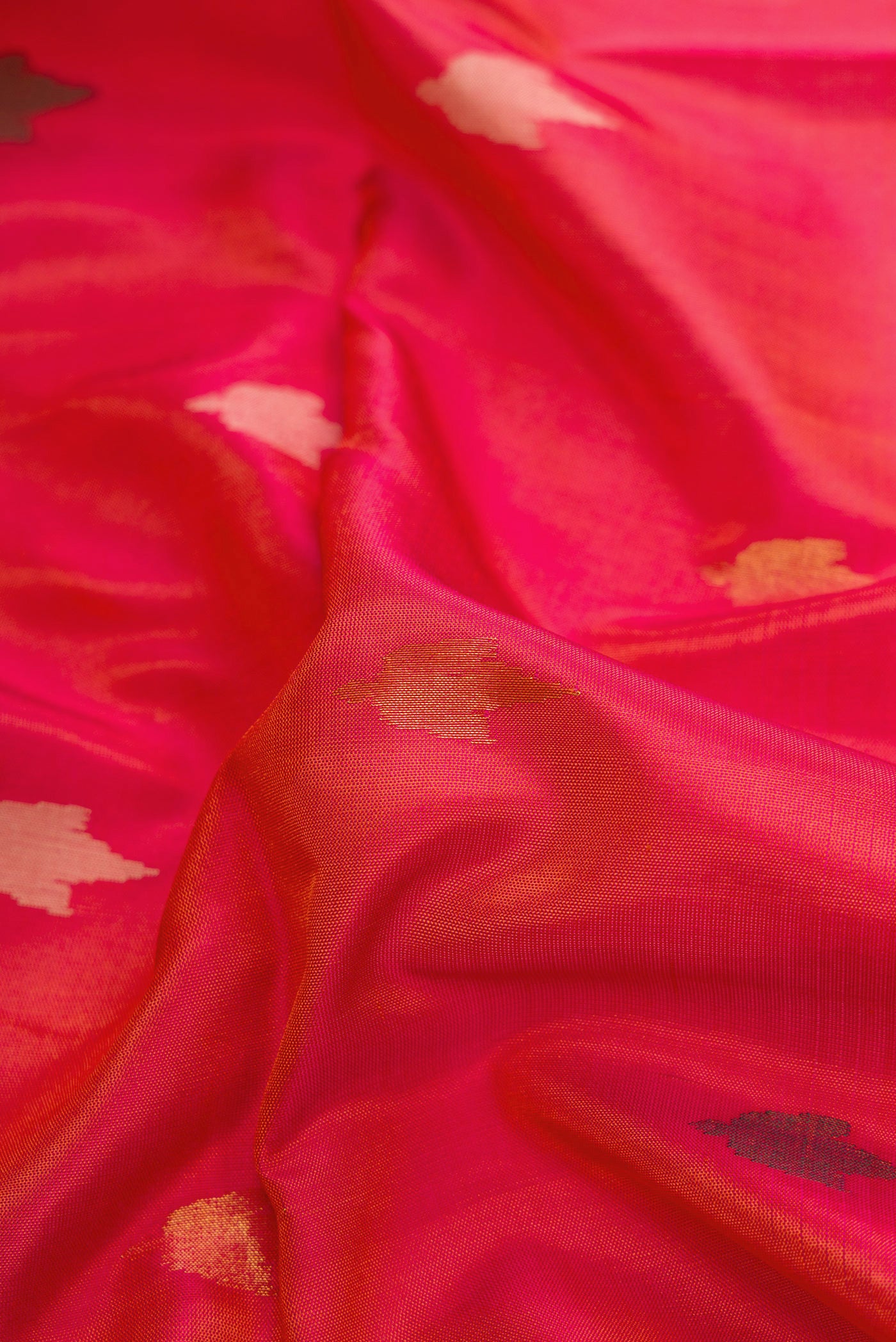 Close up of Coral Dual Tone Uppada Silk Saree with Zari And Thread Butta on the body and Zari Border.  displaying folds