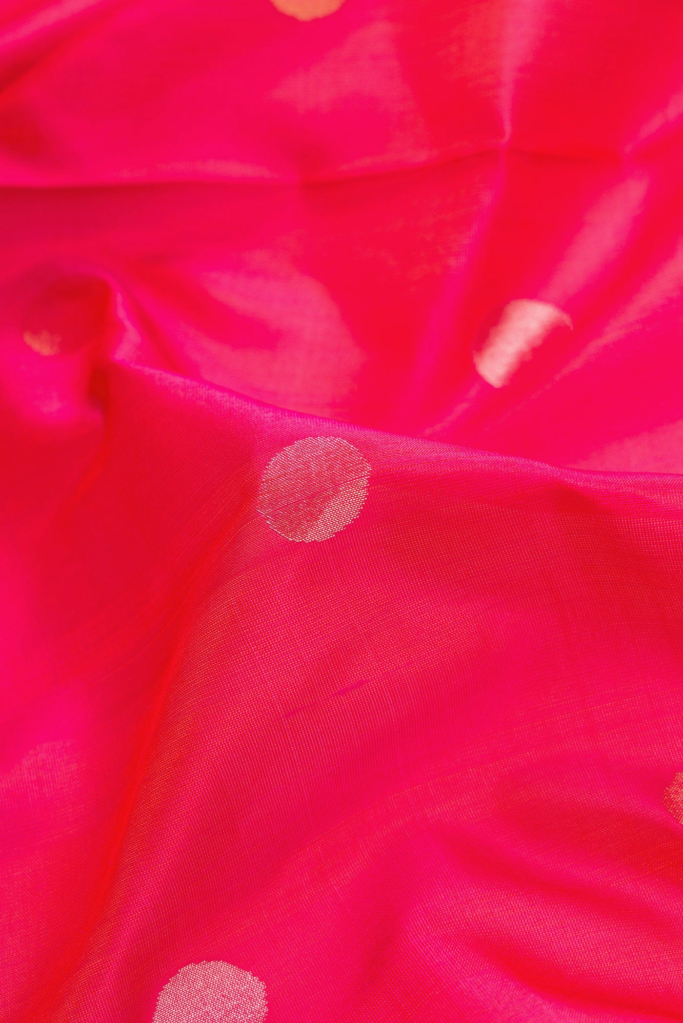 Close up of Dark Pink Dual Tone Uppada Silk Saree with Zari Butta on the body and Zari Border.  displaying folds