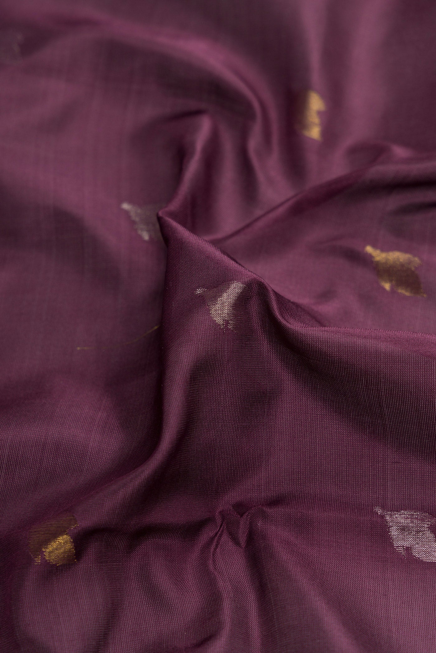 Close up of Brown Dual Tone Uppada Silk Saree with Zari Butta on the body and Zari Border.  displaying folds