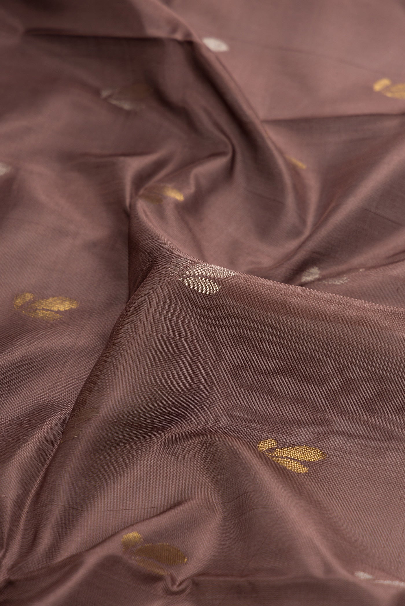 Close up of Brown Dual Tone Soft Silk Saree with Zari Butta on the body and Zari Border.  displaying folds
