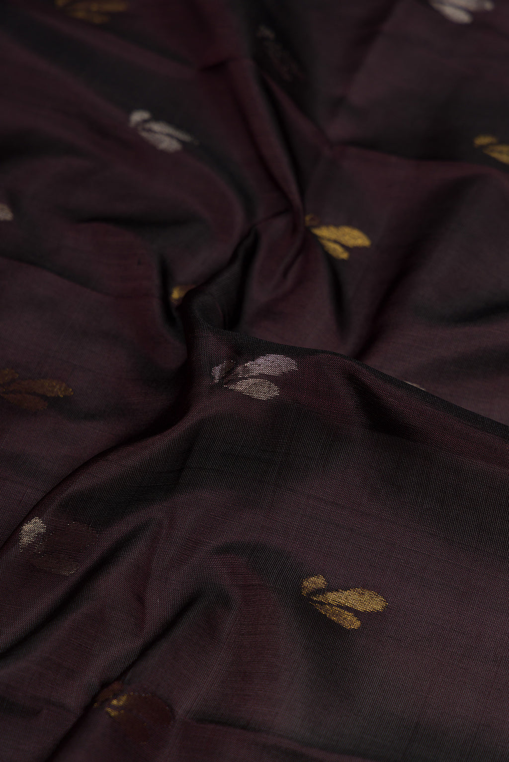 Close up of Coffee Brown Dual Tone Soft Silk Saree with Zari Butta on the body and Zari Border.  displaying folds