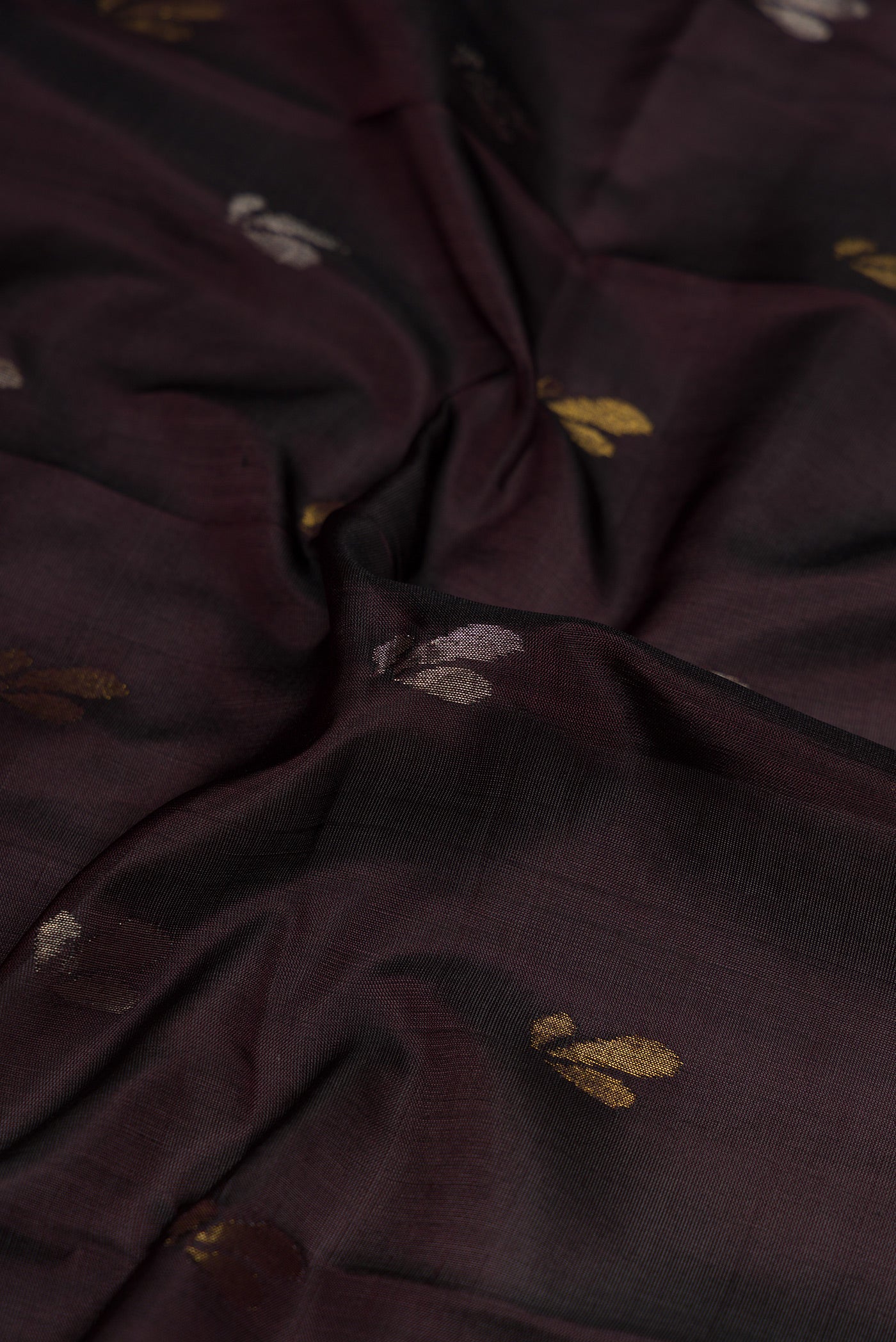 Close up of Coffee Brown Dual Tone Soft Silk Saree with Zari Butta on the body and Zari Border.  displaying folds