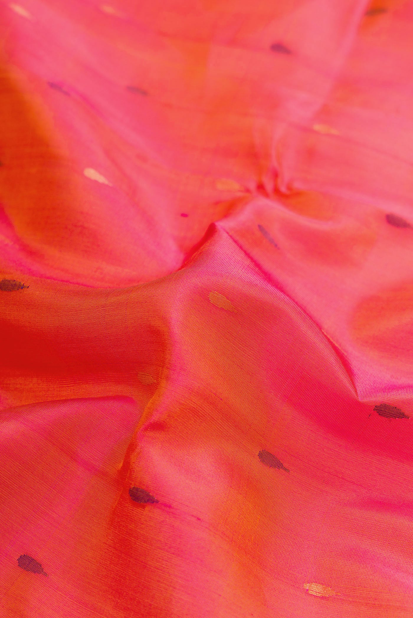 Close up of Coral Dual Tone Uppada Silk Saree with Zari And Thread Butta on the body and Zari Border.  displaying folds