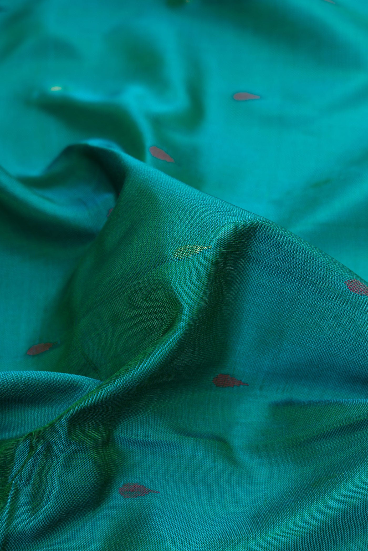 Close up of Peacock Blue Dual Tone Uppada Silk Saree with Zari And Thread Butta on the body and Zari Border.  displaying folds