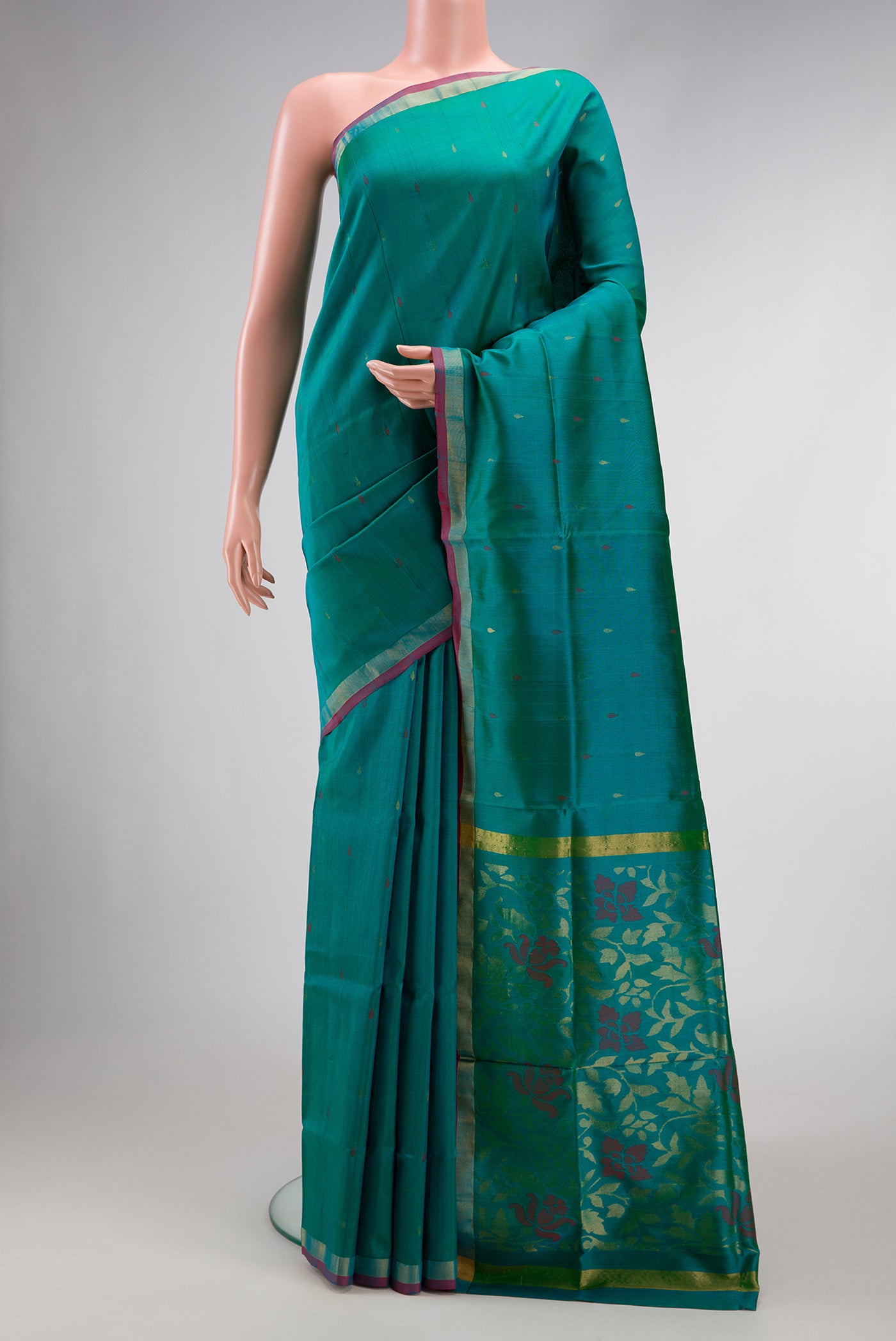 Peacock Blue Dual Tone Uppada Silk Saree with Zari And Thread Butta on the body and Zari Border.  displayed on a mannequin