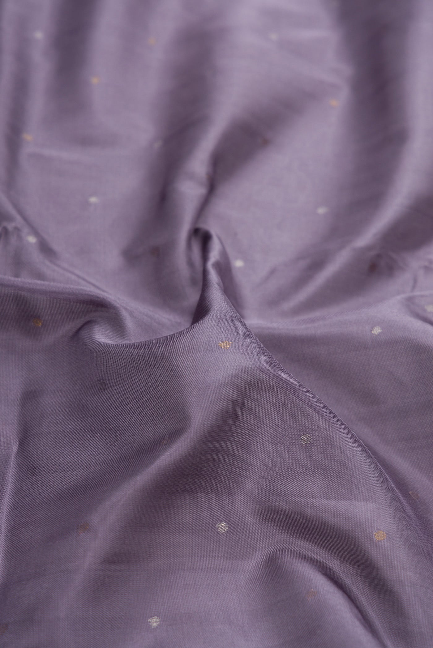 Close up of Grey Dual Tone Uppada Silk Saree with Zari Butta on the body and Zari Border.  displaying folds