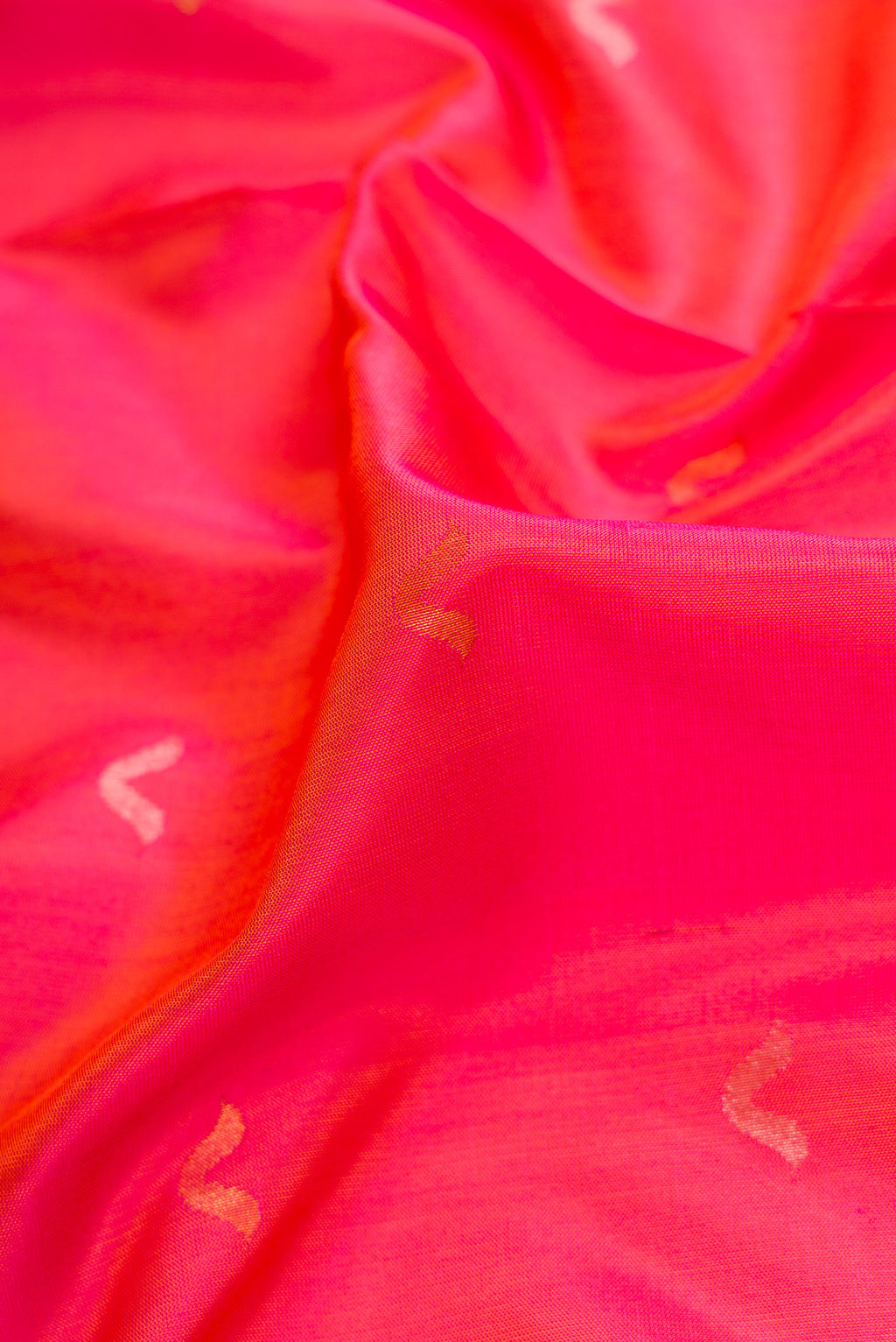 Close up of Coral Dual Tone Uppada Silk Saree with Zari Butta on the body and Zari Border.  displaying folds