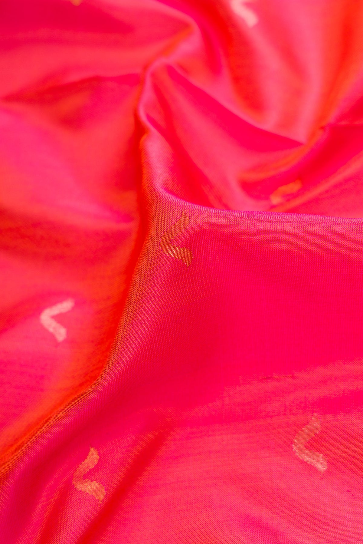 Close up of Coral Dual Tone Uppada Silk Saree with Zari Butta on the body and Zari Border.  displaying folds