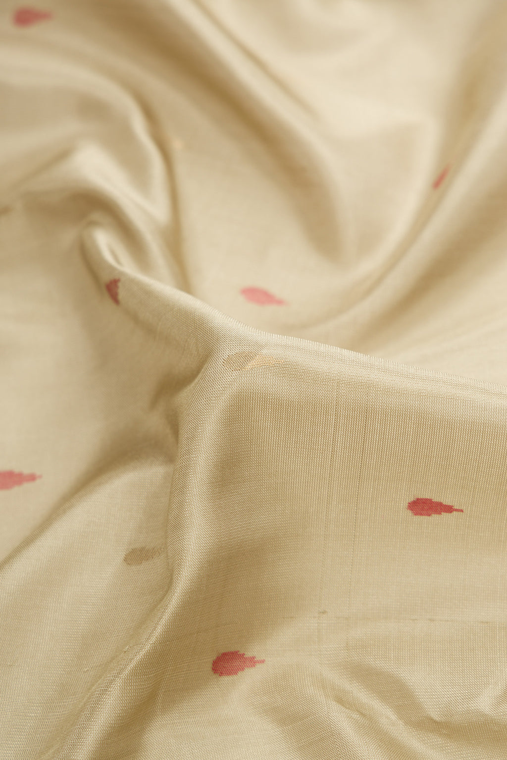 Close up of Beige Dual Tone Uppada Silk Saree with Zari And Thread Butta on the body and Temple Border.  displaying folds