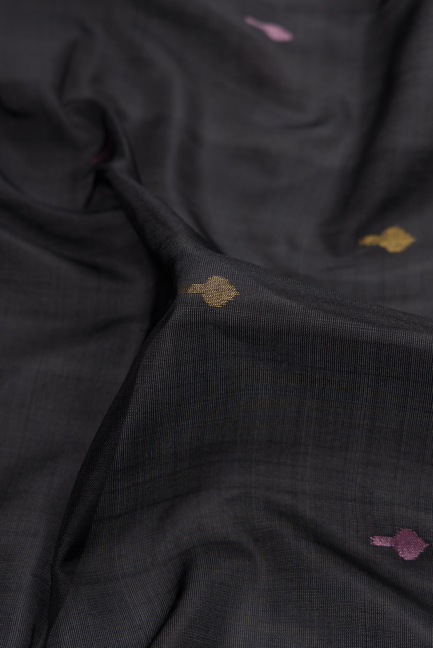 Close up of Black Dual Tone Uppada Silk Saree with Zari And Thread Butta on the body and Zari Border.  displaying folds