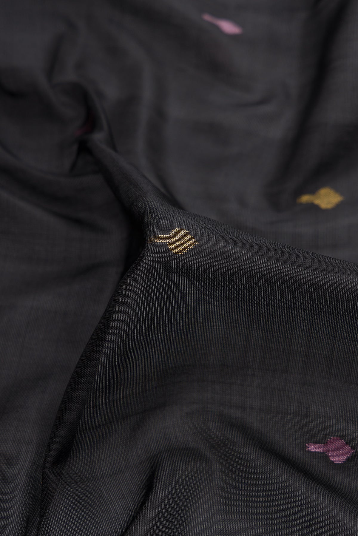Close up of Black Dual Tone Uppada Silk Saree with Zari And Thread Butta on the body and Zari Border.  displaying folds