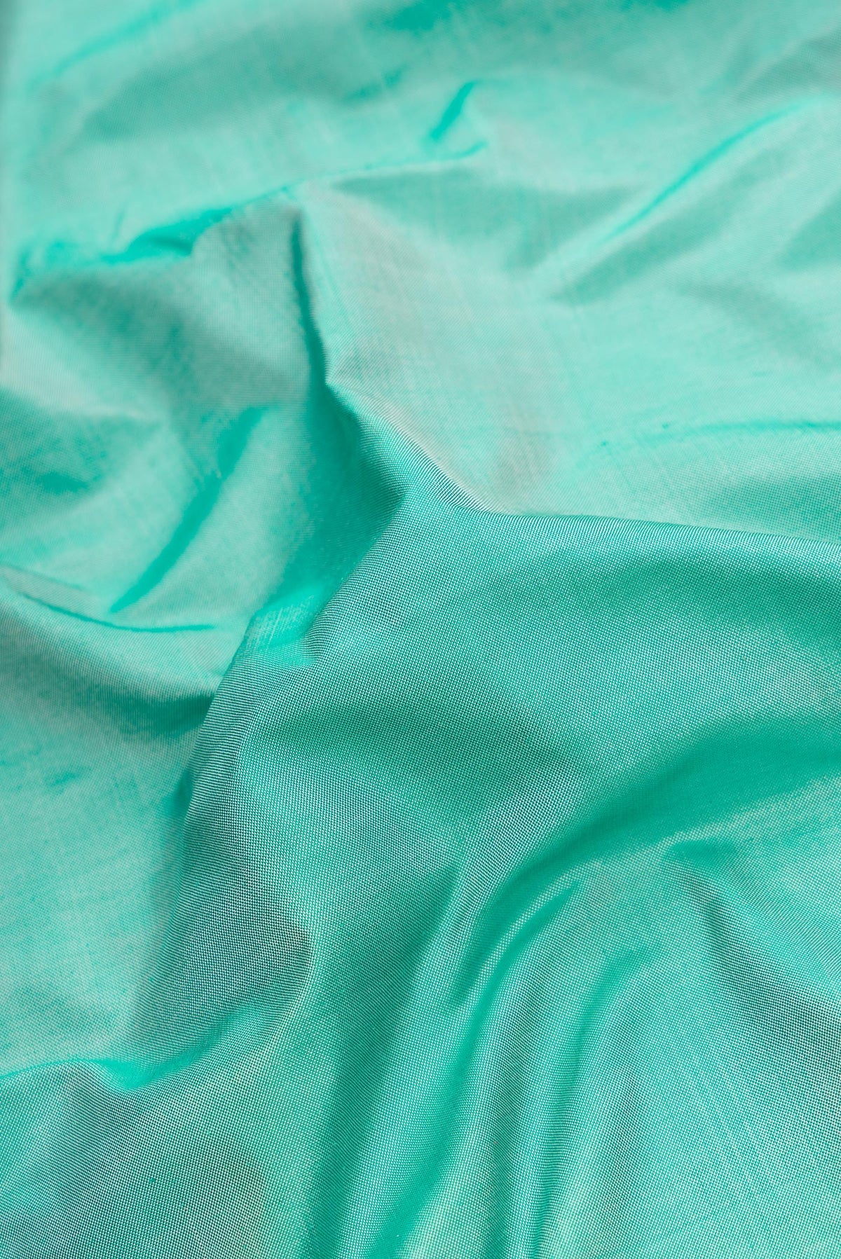 Close up of Green Dual Tone Double Ikat Saree with Plain Body and Temple Border.  displaying folds