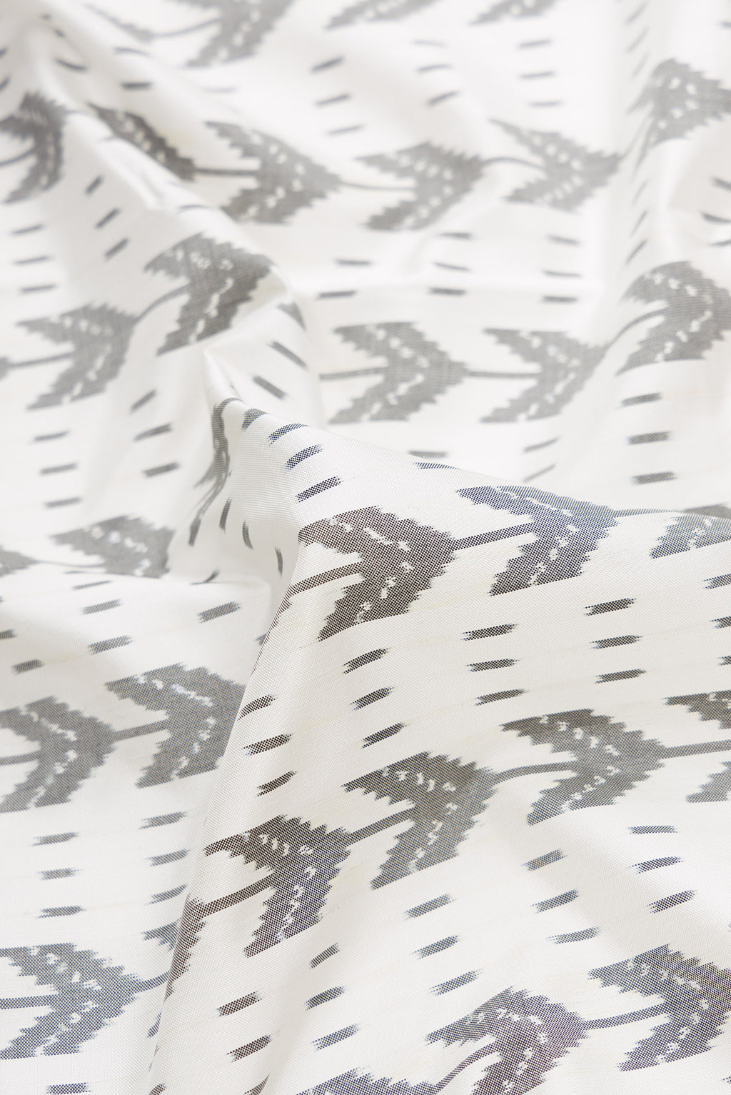 Close up of Off White Dual Tone Double Ikat Saree with Ikat Print on the body and Zari Border.  displaying folds