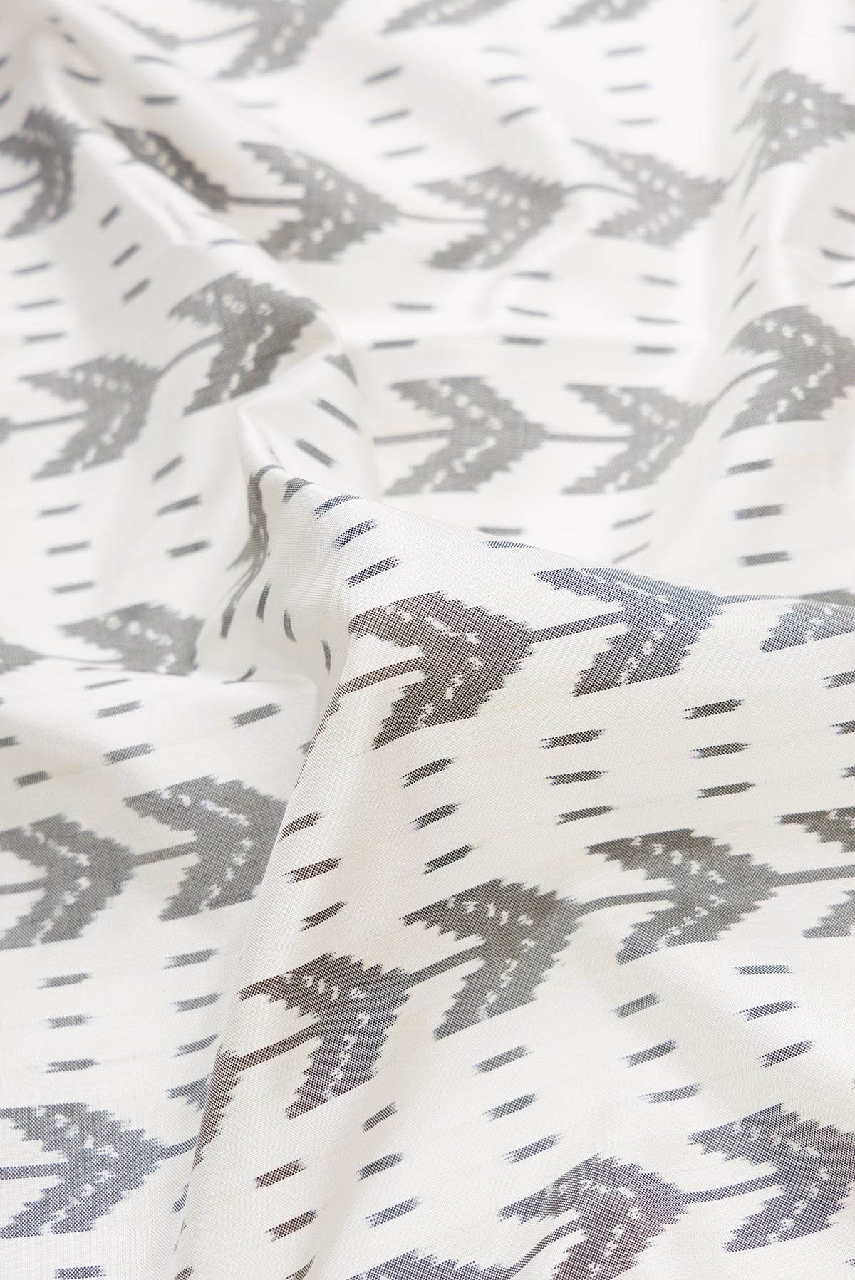 Close up of Off White Dual Tone Double Ikat Saree with Ikat Print on the body and Zari Border.  displaying folds