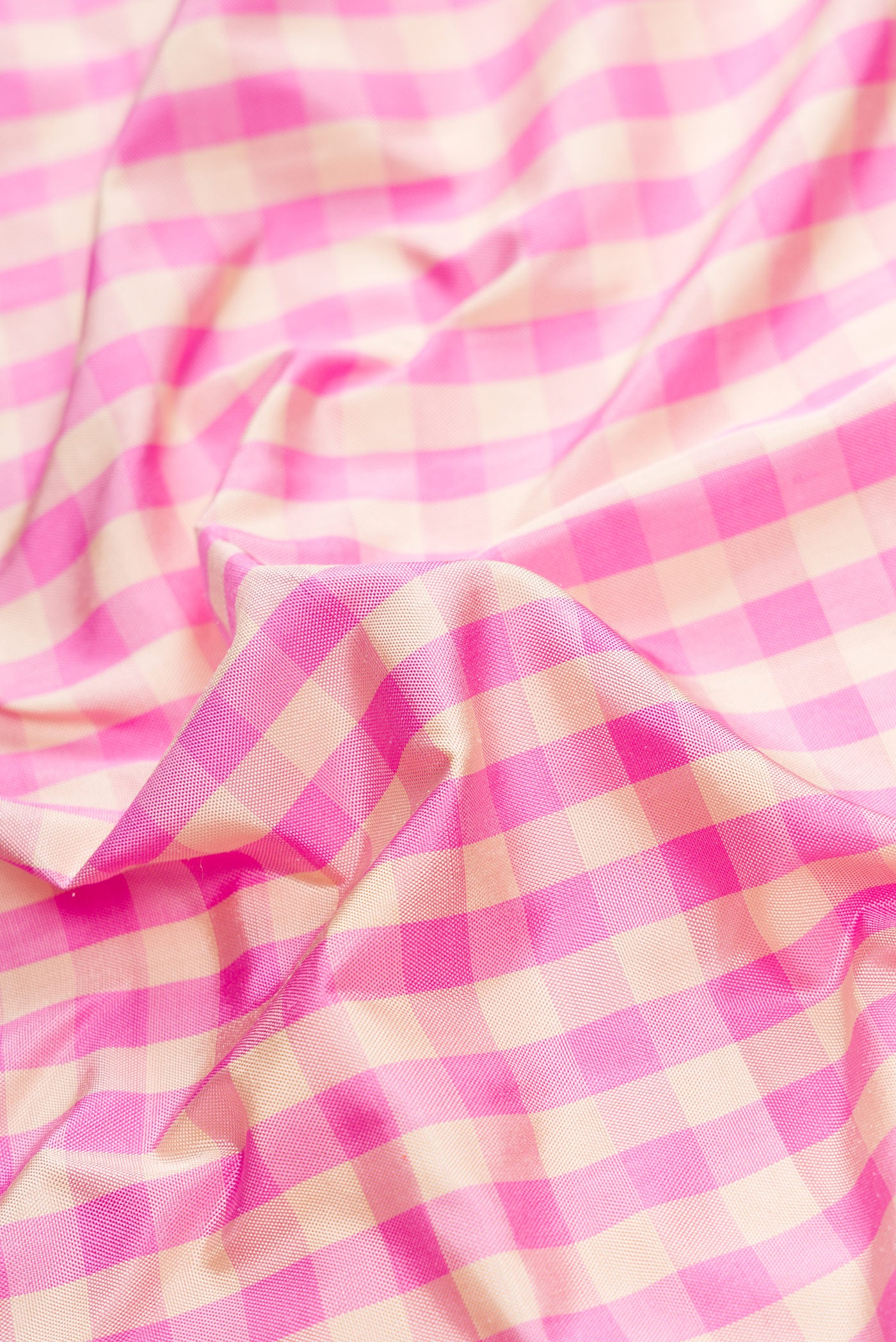Close up of Pure Silk Pure Zari Pink Dual Tone Double Ikat Saree with Checked design on the body and Thread Border.  displaying folds