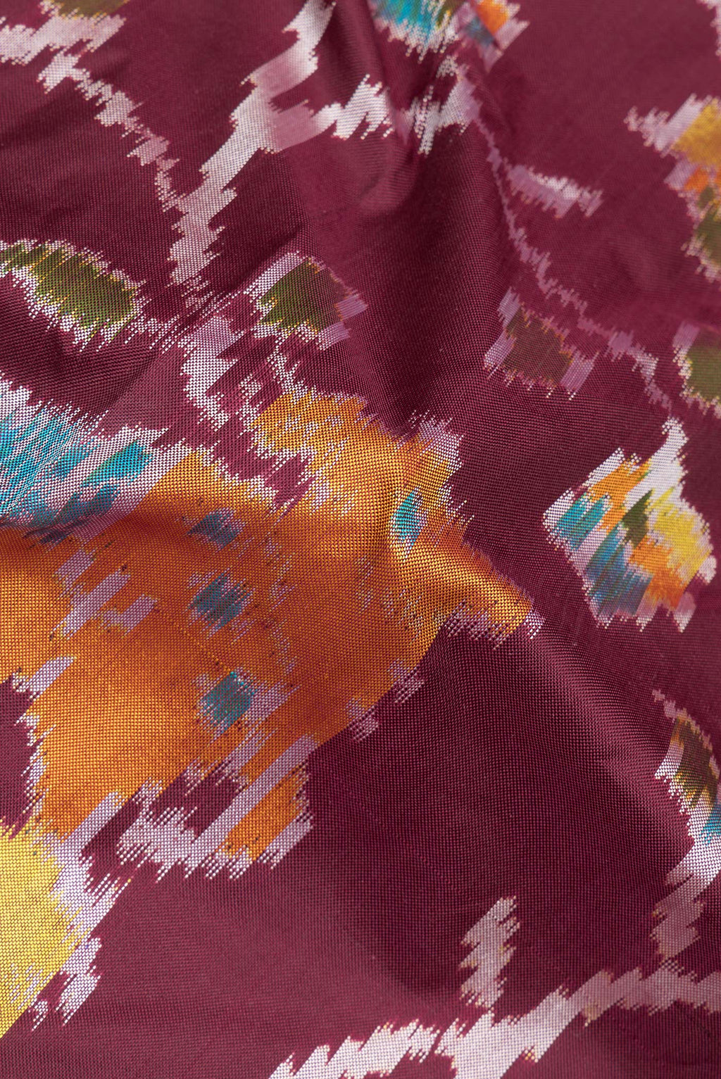 Close up of Pure Silk Maroon Pochampally Saree with Ikat design on the body and Thread Border.  displaying folds