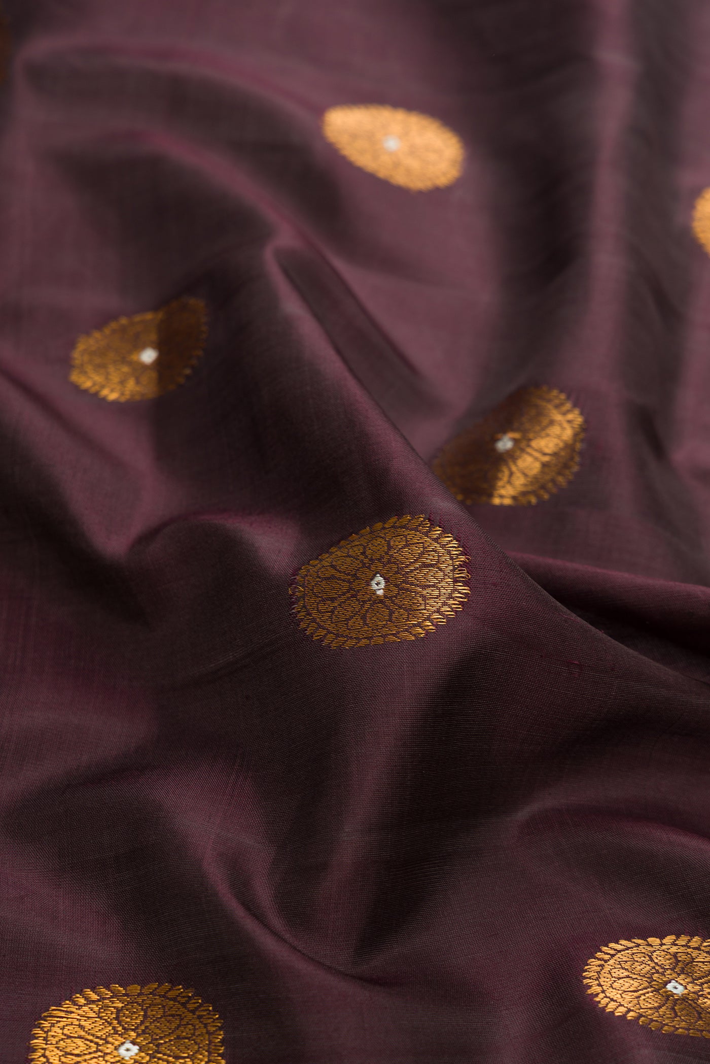 Close up of Coffee Brown Dual Tone Gadwal Silk Saree with Zari And Thread Butta on the body and Zari Border.  displaying folds