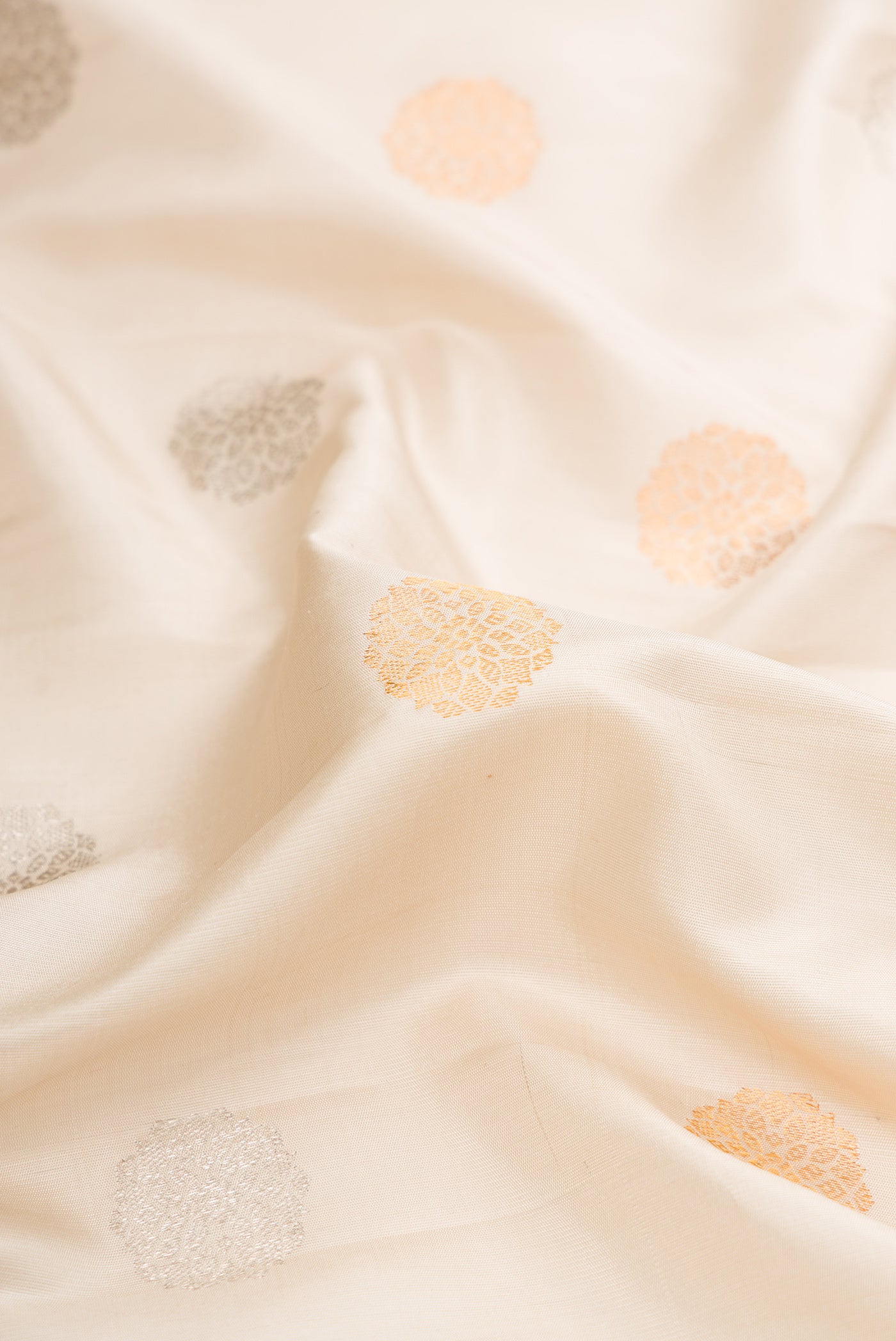 Close up of Beige Dual Tone Gadwal Silk Saree with Zari Butta on the body and Zari Border.  displaying folds
