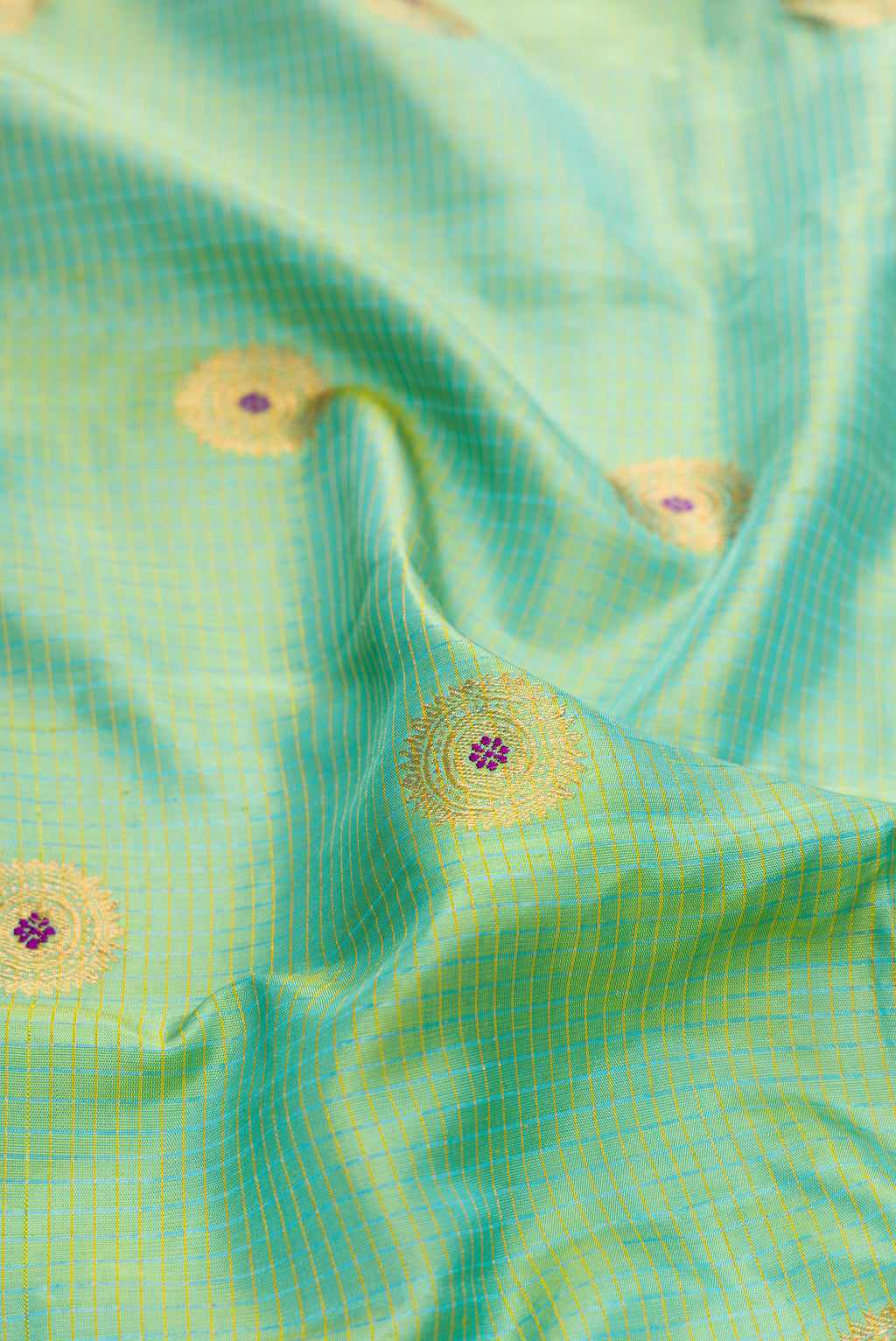 Close up of Light Green Dual Tone Gadwal Silk Saree with Zari And Thread Butta on the body and Zari Border.  displaying folds