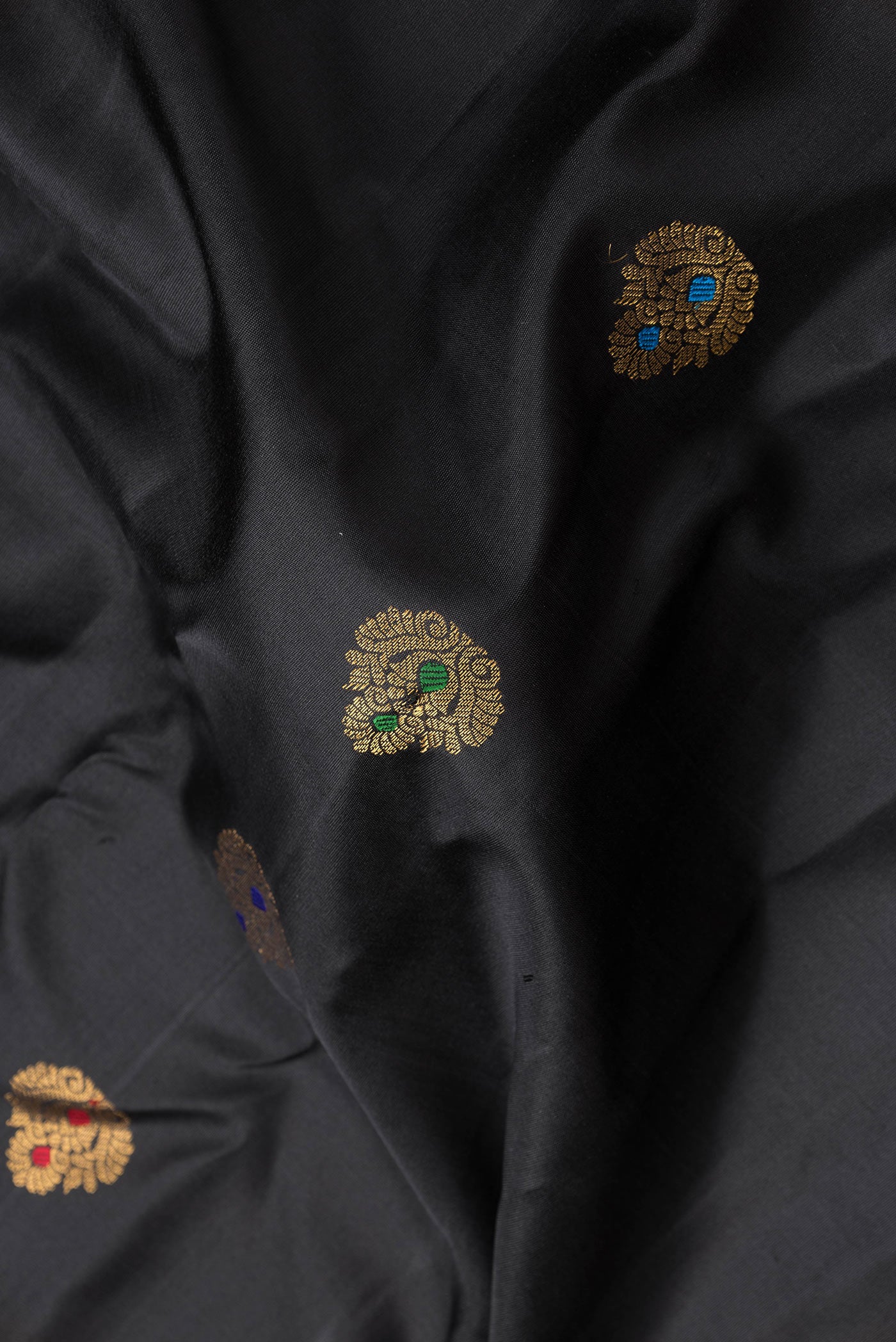 Close up of Black Dual Tone Gadwal Silk Saree with Zari And Thread Butta on the body and Zari Border.  displaying folds