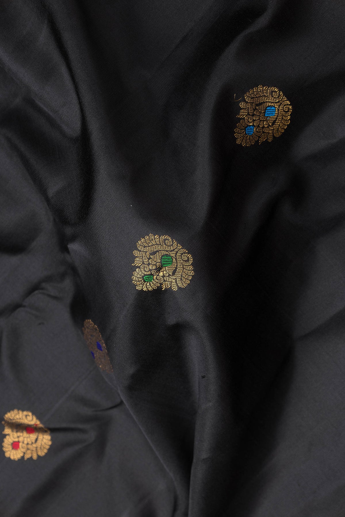 Close up of Black Dual Tone Gadwal Silk Saree with Zari And Thread Butta on the body and Zari Border.  displaying folds
