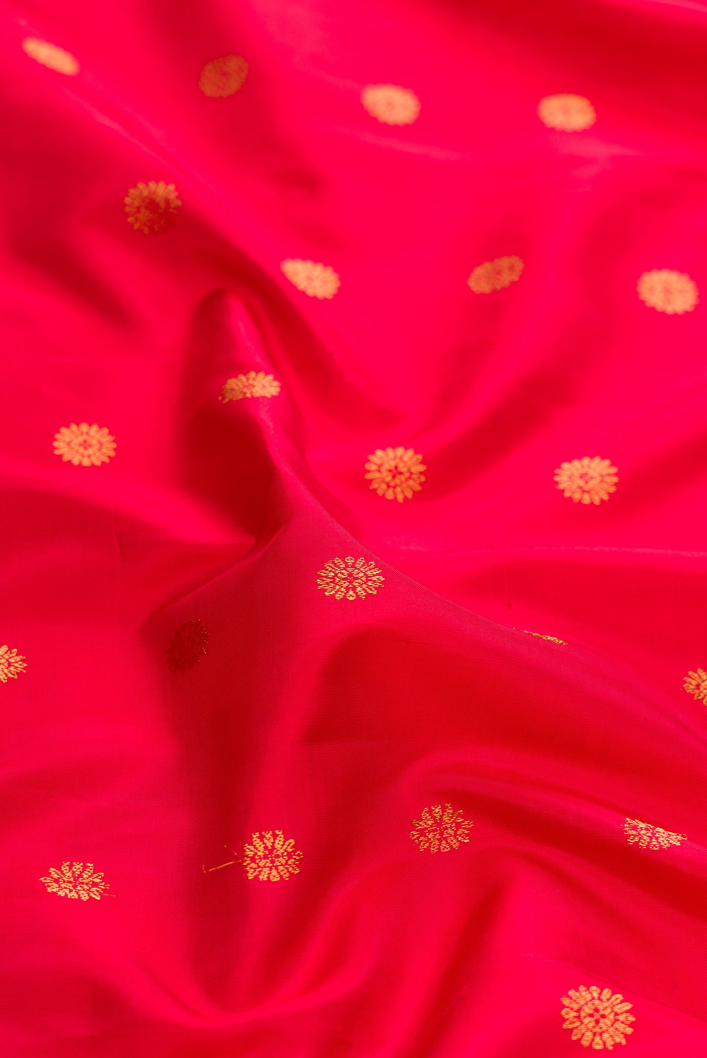 Close up of Red Dual Tone Gadwal Silk Saree with Zari Butta on the body and Zari And Thread Border.  displaying folds