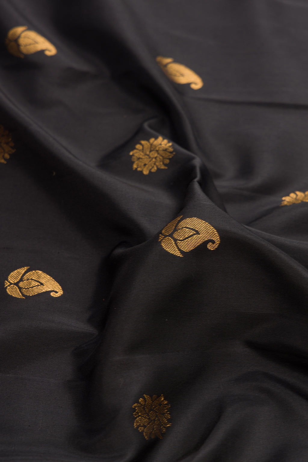 Close up of Black Dual Tone Gadwal Silk Saree with Zari Butta on the body and Paithani Border.  displaying folds