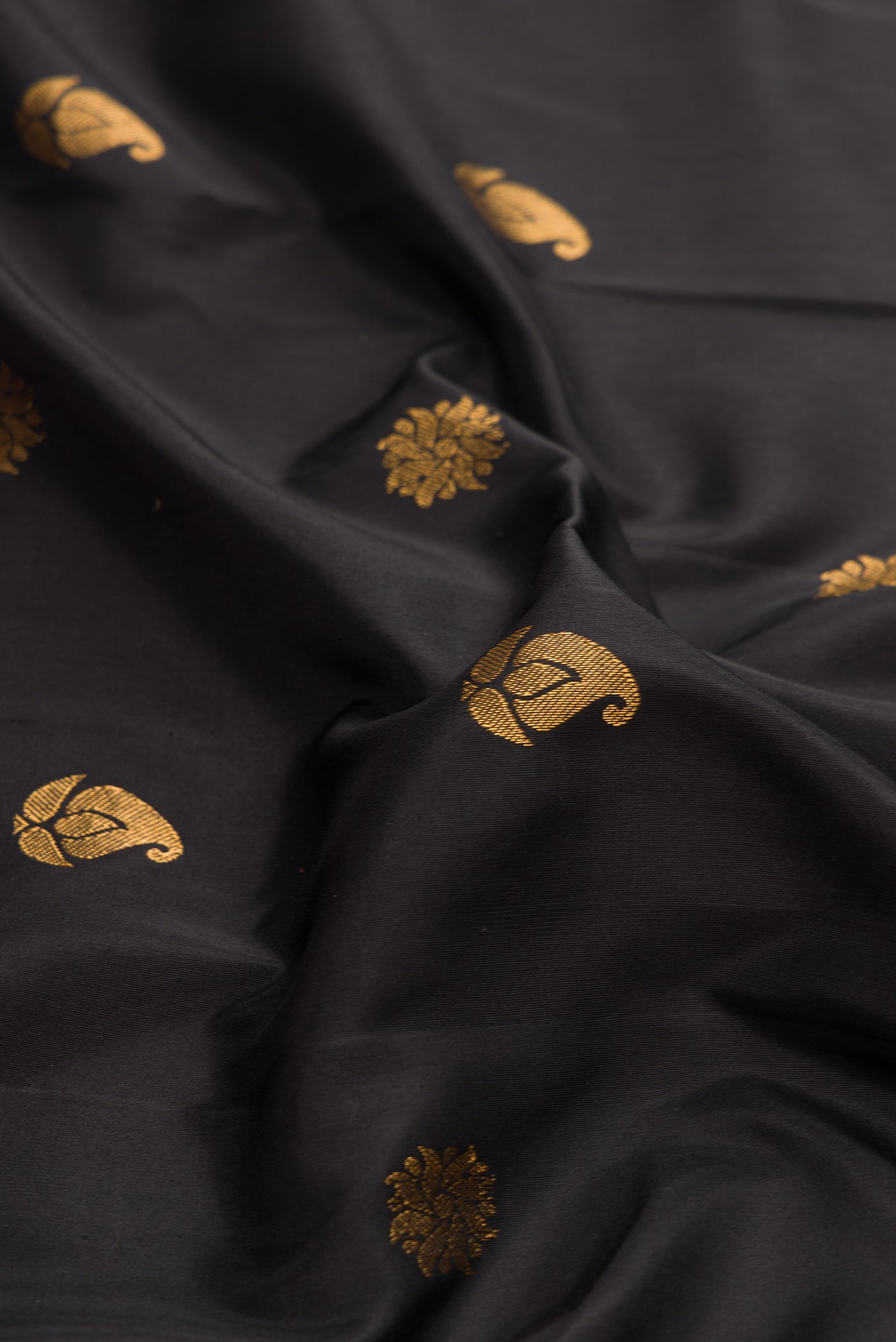 Close up of Black Dual Tone Gadwal Silk Saree with Zari Butta on the body and Paithani Border.  displaying folds