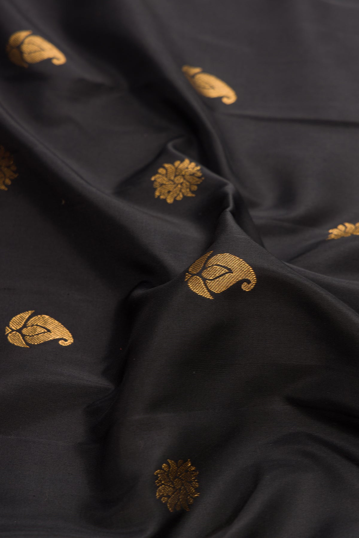Close up of Black Dual Tone Gadwal Silk Saree with Zari Butta on the body and Paithani Border.  displaying folds