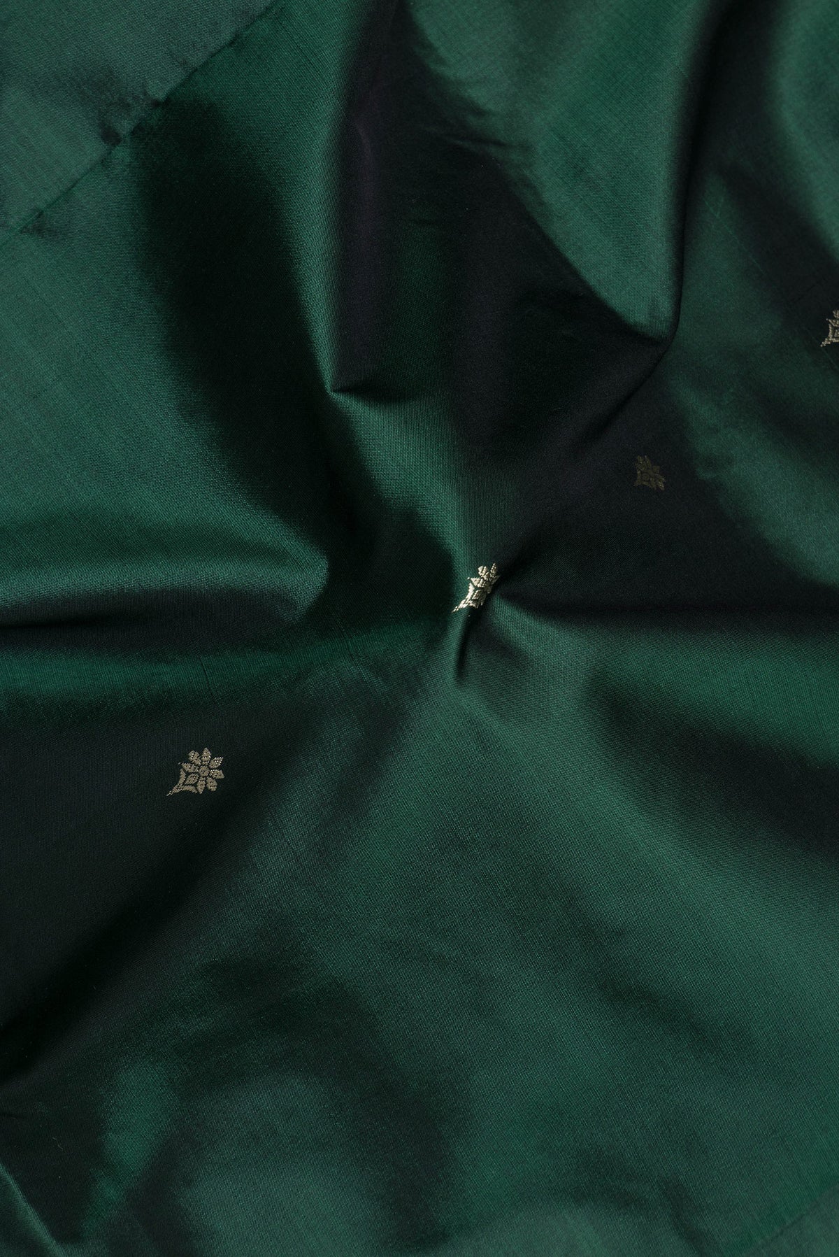 Close up of Bottle Green Banarasi Silk Saree with Thread Butta on the body and Thread Border.  displaying folds