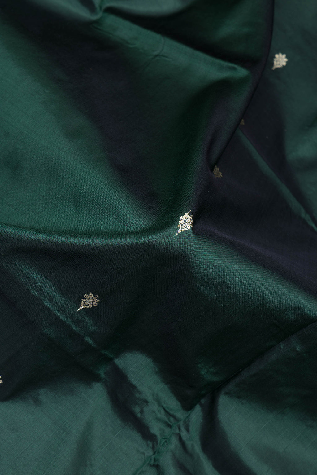 Close up of Bottle Green Banarasi Silk Saree with Thread Butta on the body and Thread Border.  displaying folds