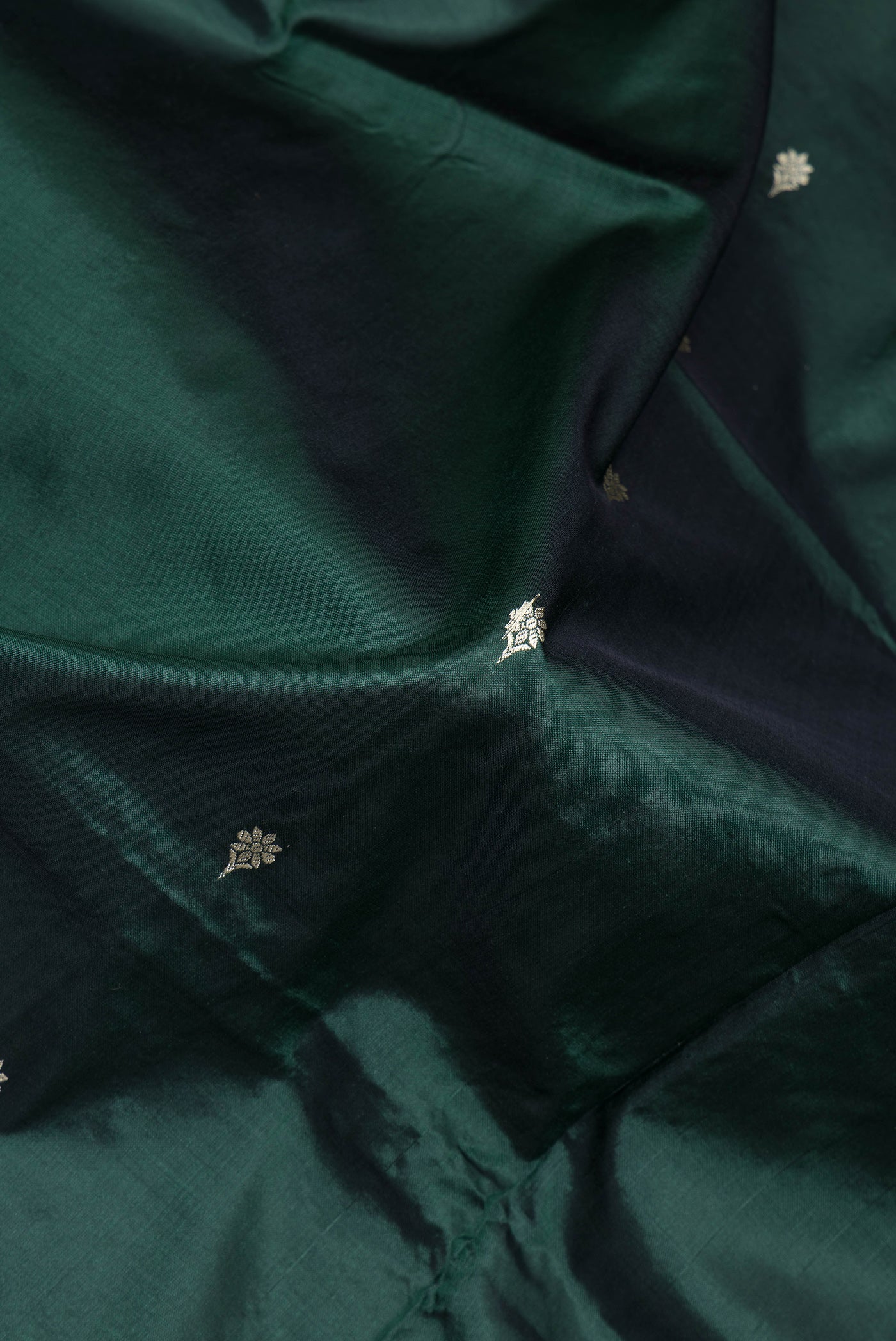 Close up of Bottle Green Banarasi Silk Saree with Thread Butta on the body and Thread Border.  displaying folds