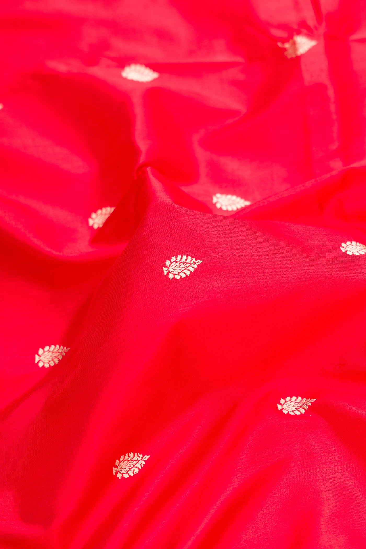 Close up of Red Dual Tone Banarasi Silk Saree with Thread Butta on the body and Thread Border.  displaying folds