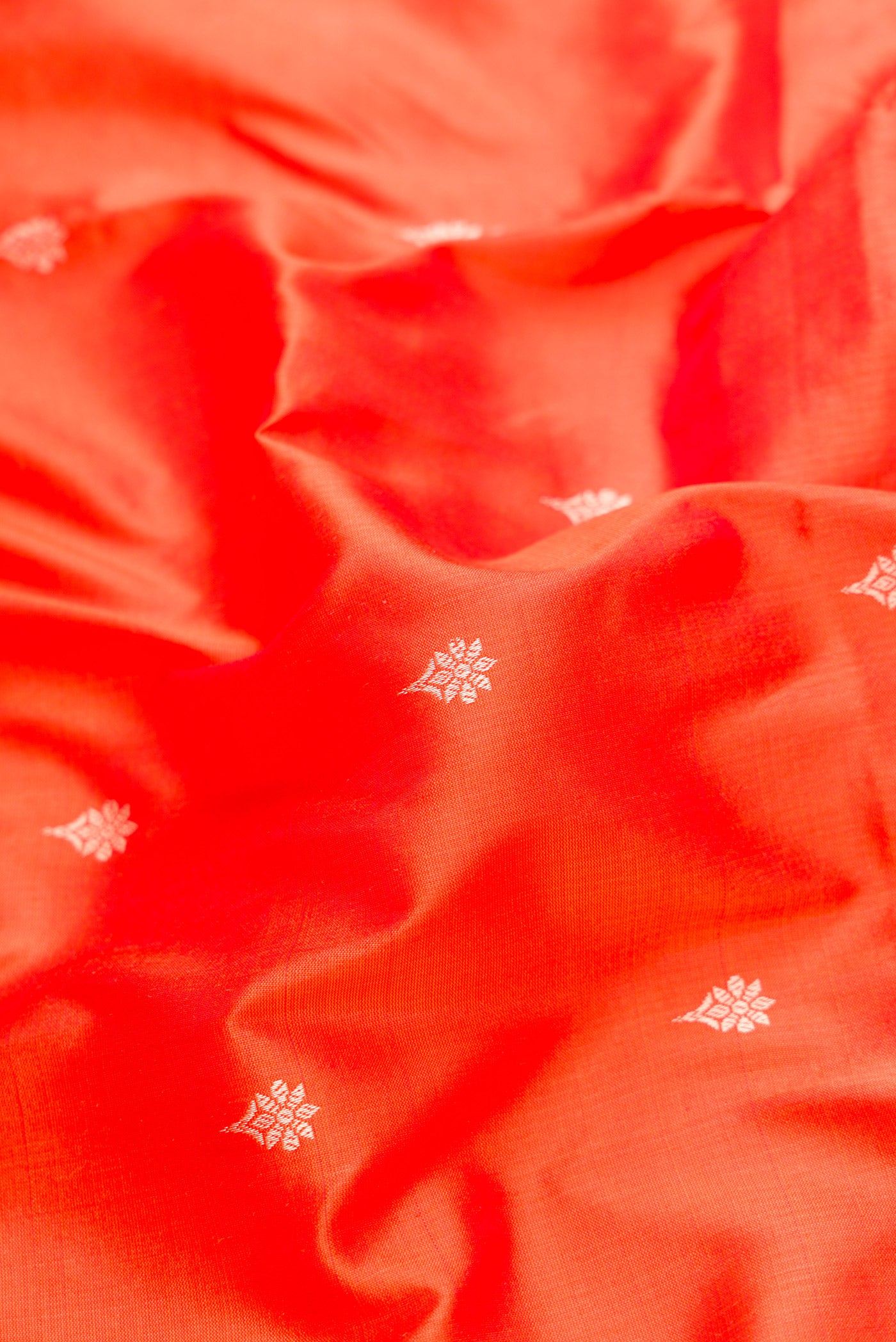 Close up of Orange Dual Tone Banarasi Silk Saree with Thread Butta on the body and Thread Border.  displaying folds