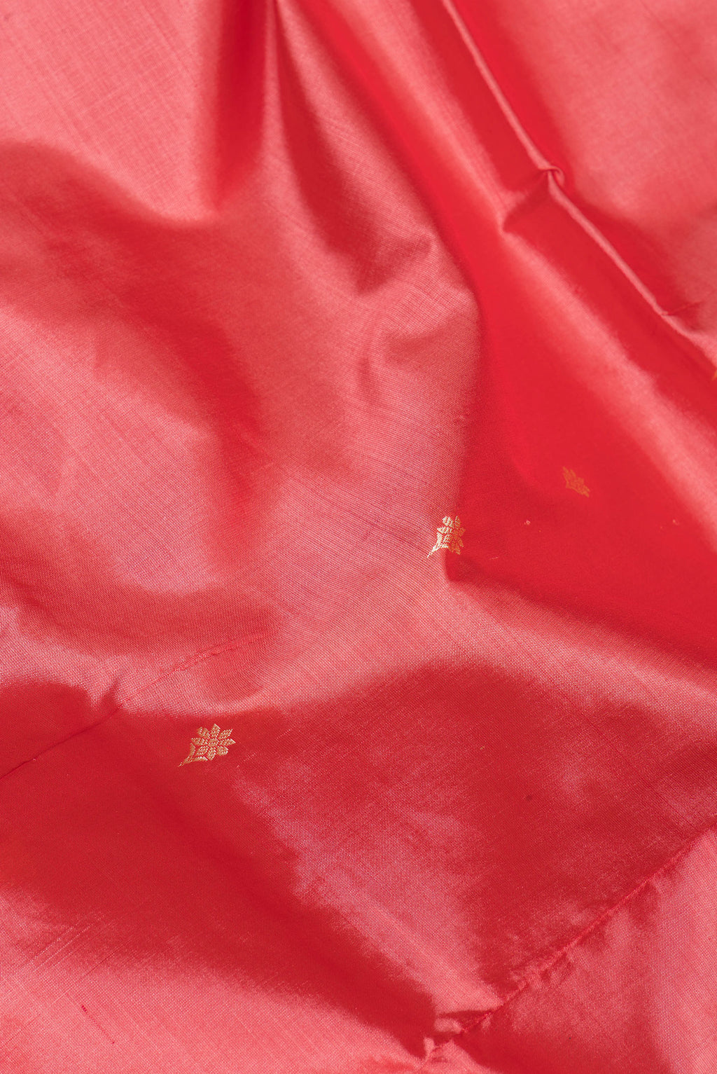 Close up of Coral Banarasi Silk Saree with Thread Butta on the body and Thread Border.  displaying folds