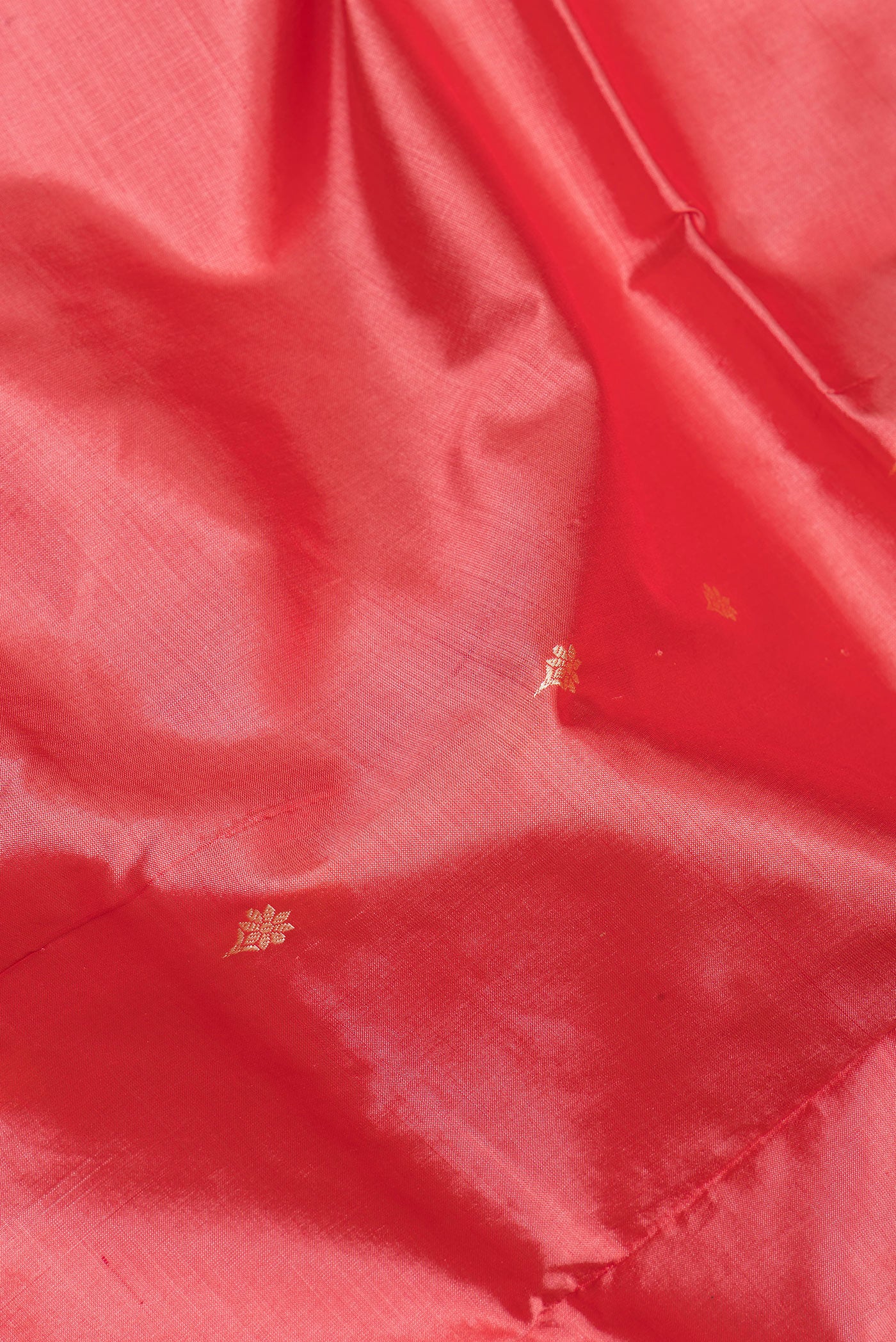 Close up of Coral Banarasi Silk Saree with Thread Butta on the body and Thread Border.  displaying folds